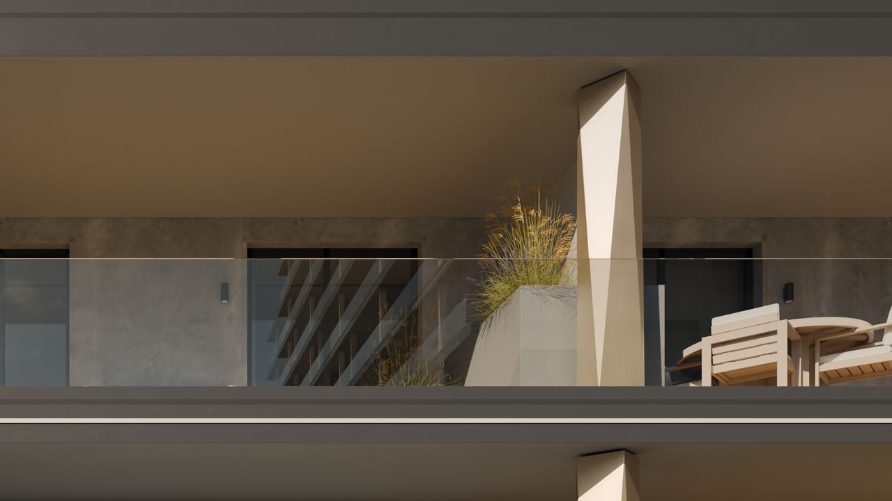 Detaliu de fațadă la clădirea B3: o coloană fațetată în nuanță șampanie, o balustradă din sticlă transparentă, o jardinieră cu ierburi și mobilier de exterior.